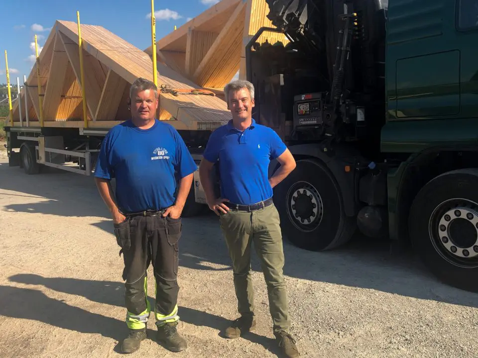 bildet viser to menn ved siden av en lastebil med takstoler