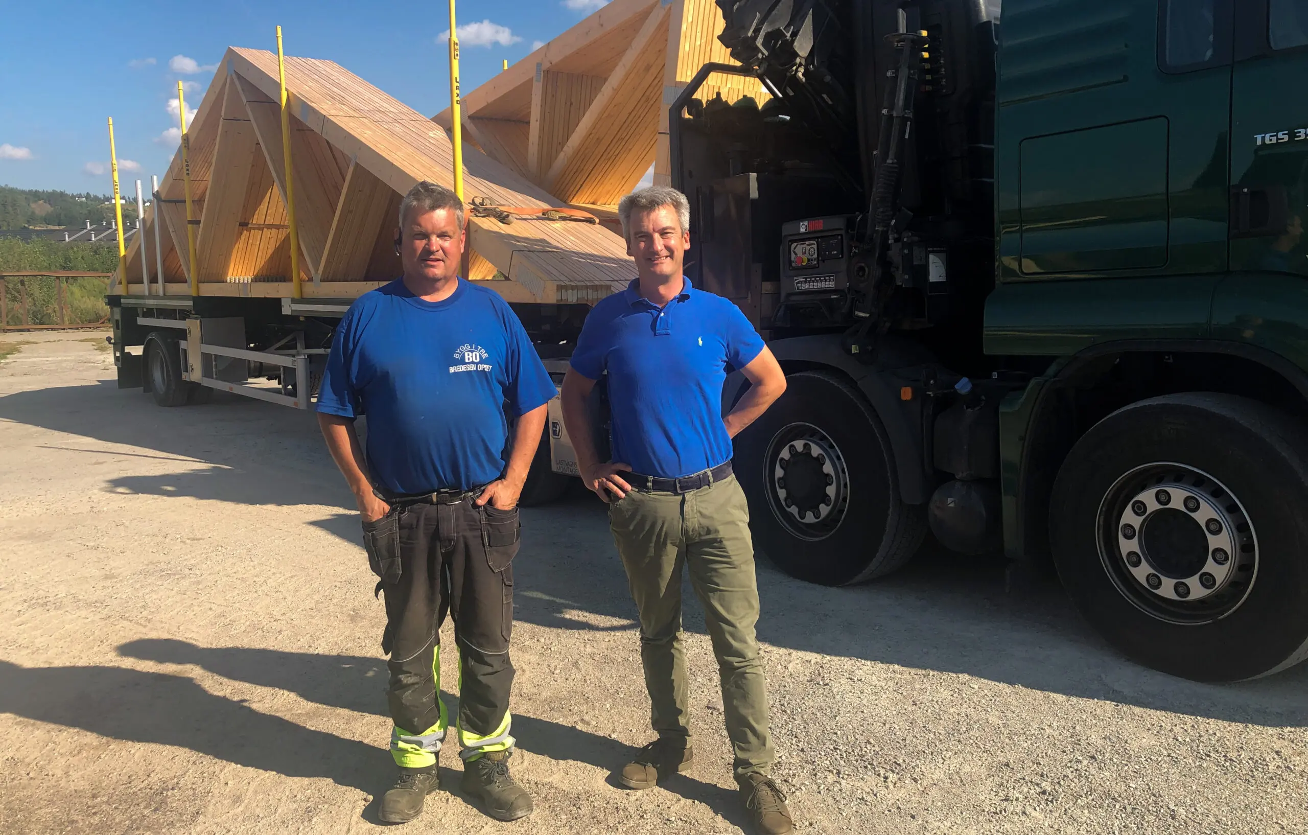 bildet viser to menn ved siden av en lastebil med takstoler