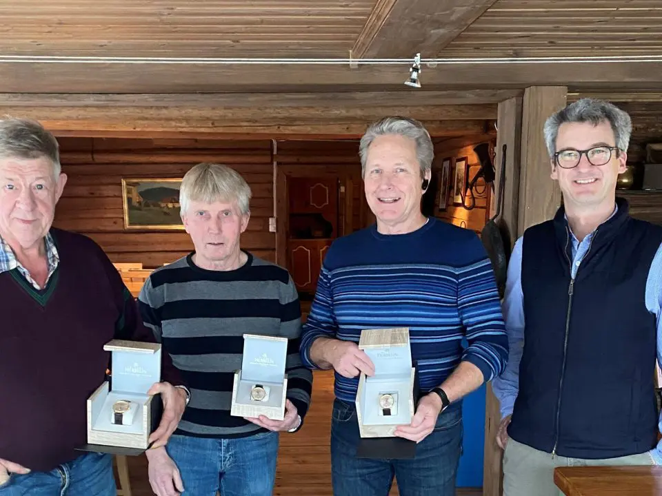 bildet viser tre menn som har fått gullklokke fra daglig leder