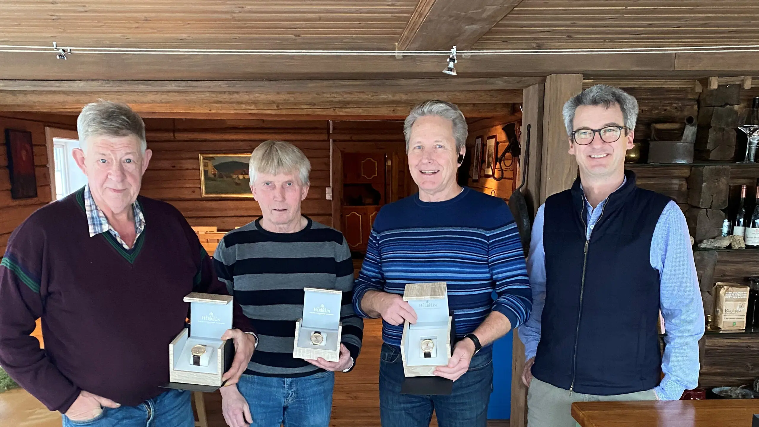 bildet viser tre menn som har fått gullklokke fra daglig leder