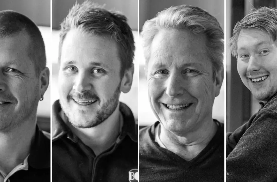 bildet viser fire menn som smiler