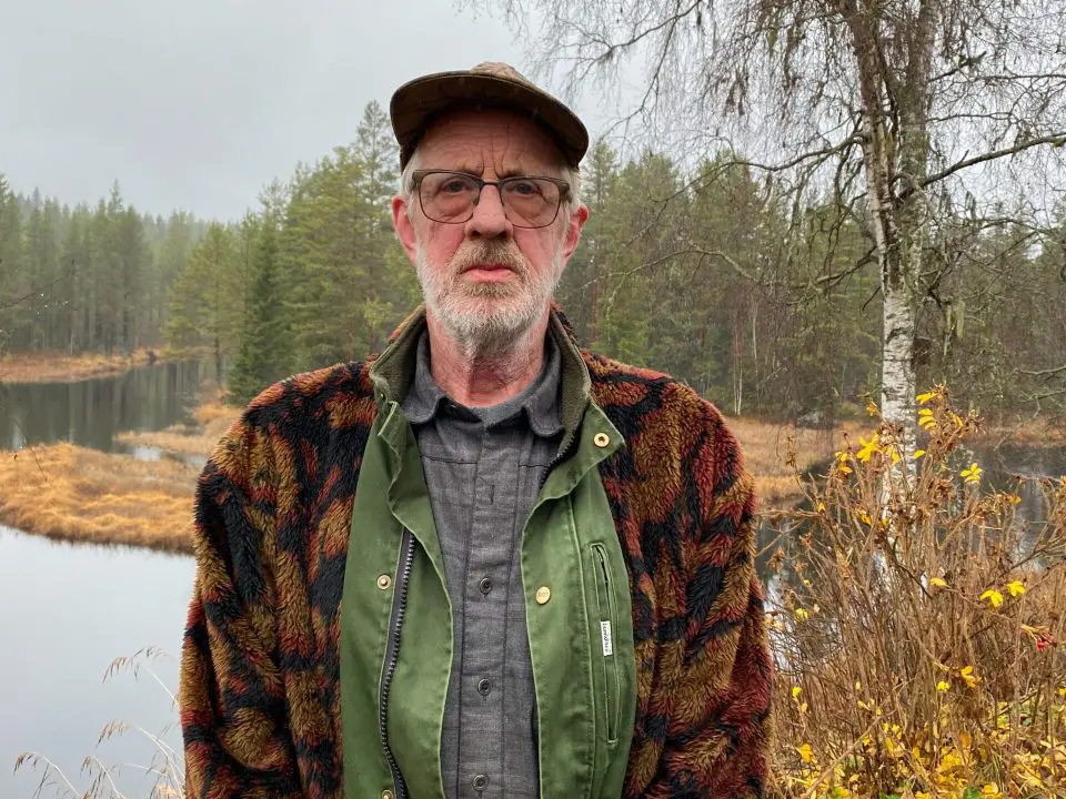 Bildet viser Kjell Skaraberget i skogen foran et vann