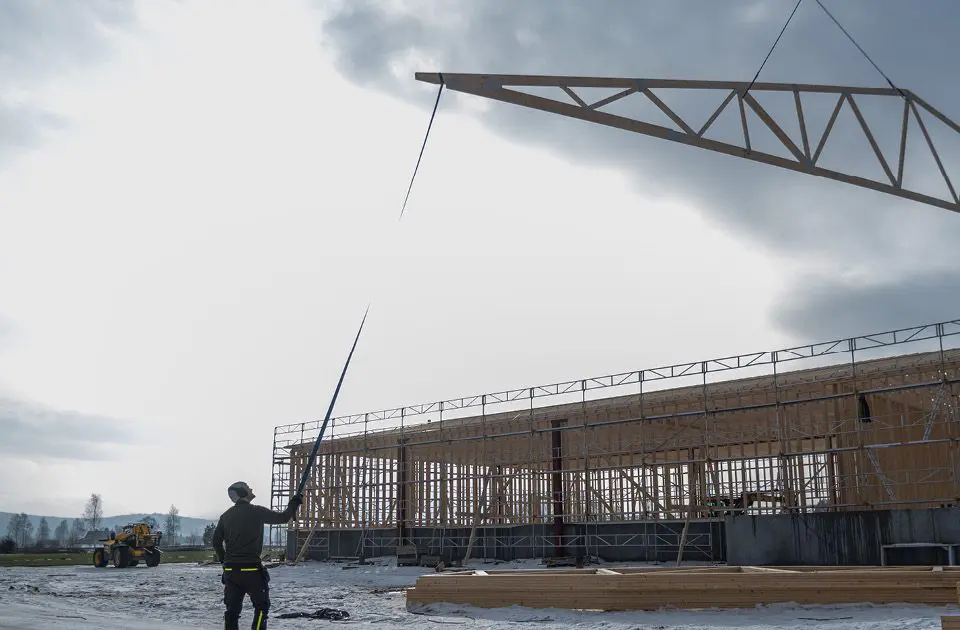 Bildet viser snekkere som heiser opp takstoler